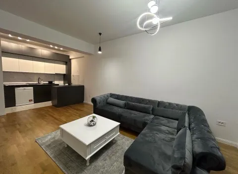Living room with a sofa and coffee table as part of an open-plan space with the kitchen. - image 2