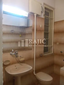 Older equipped bathroom with a sink and toilet. - image 17