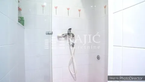 Prikaz tuš kabine u kupatilu sa belim pločicama. - image 18