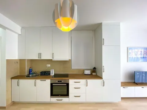 Modern white kitchen with wooden countertop and built-in appliances. - image 7