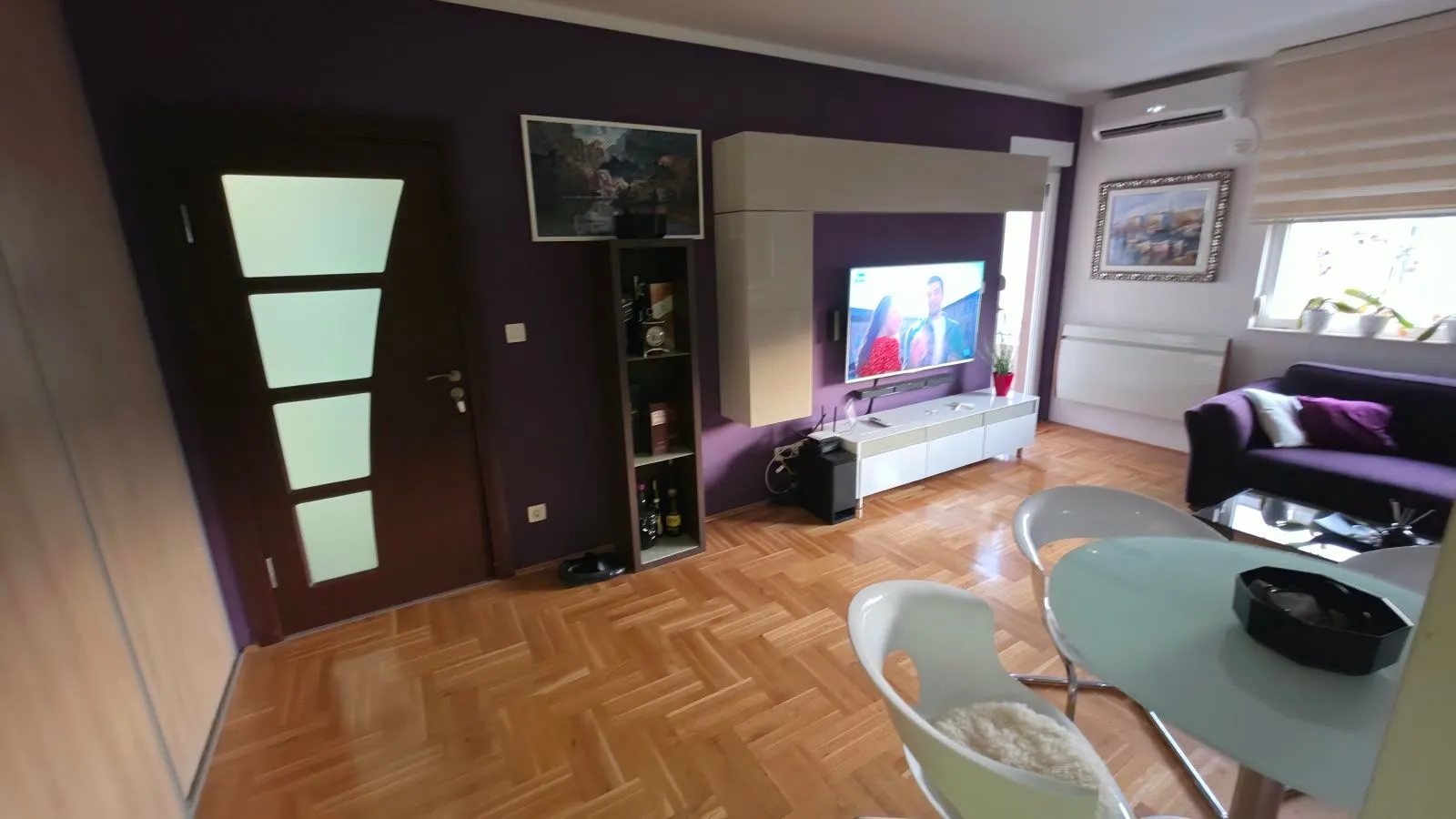 Living room with a sofa, TV, and dining table.