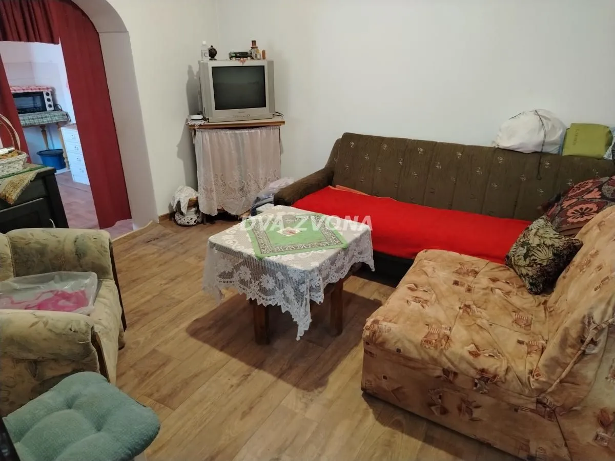 Dnevna soba sa garniturom za sedenje i televizorom.