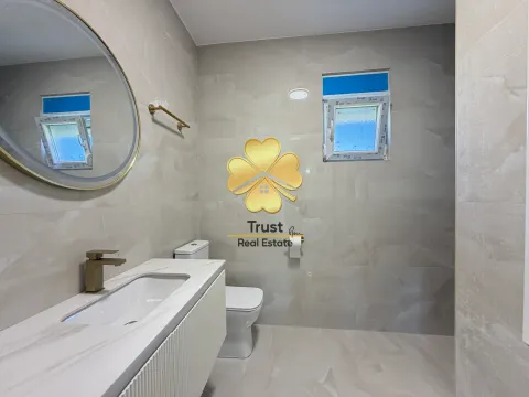 Modern bathroom with a sink, toilet, and mirror. - image 10