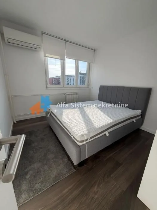 Bedroom with a double bed, window, and air conditioning.