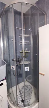 Bathroom with a tiled shower cabin. - image 9