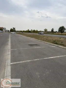 Asphalted parking space next to the road with marked spots. - image 8