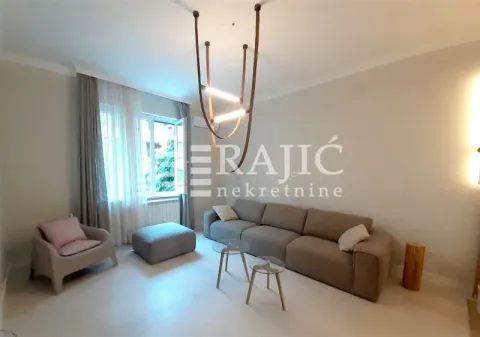 Living room with a sofa, armchair, and modern chandelier. - image 3