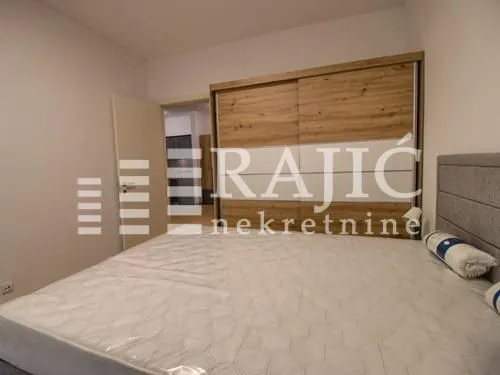 Furnished bedroom with a double bed and a large wardrobe.