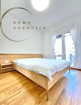 Bright bedroom with a double bed and wooden flooring. - image 5