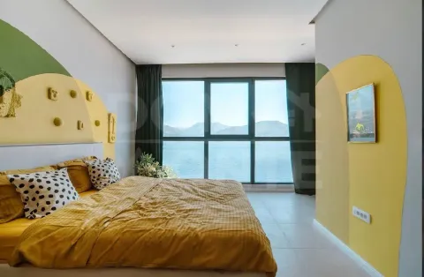 Bright bedroom with a double bed and a sea view through a large window. - image 13