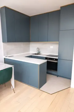 Moderna kuhinja sa plavim elementima i bijelom radnom pločom. - image 6