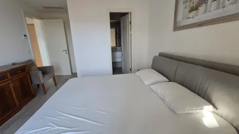 Prostrana spavaća soba sa bračnim krevetom i pogledom na kupatilo. - image 7