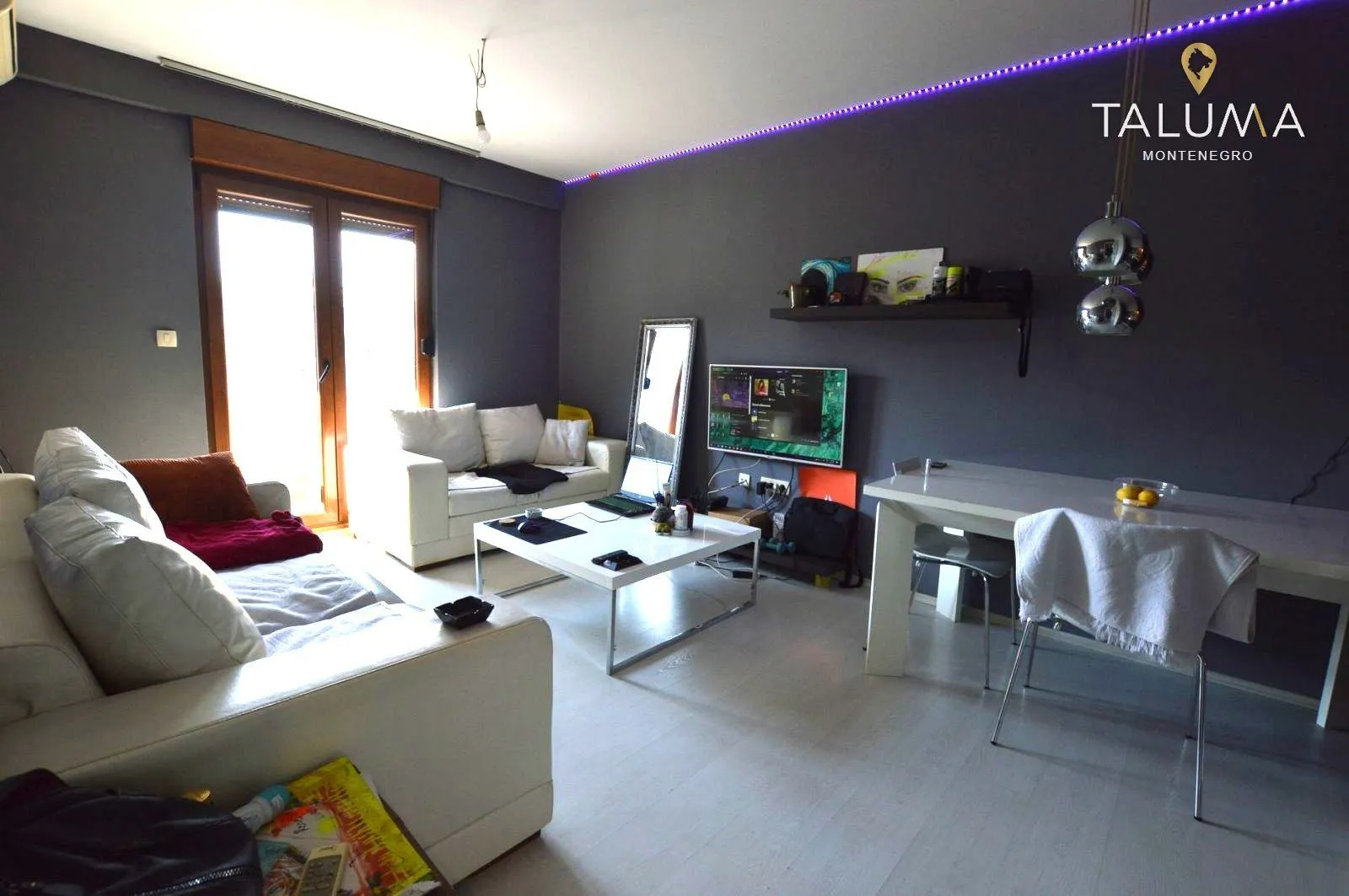 Living room with seating furniture, television, and dining table.