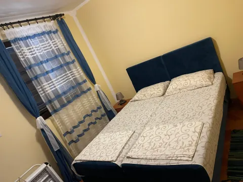 Uređena spavaća soba sa bračnim krevetom, plavim zavjesama i žutim zidovima. - image 10