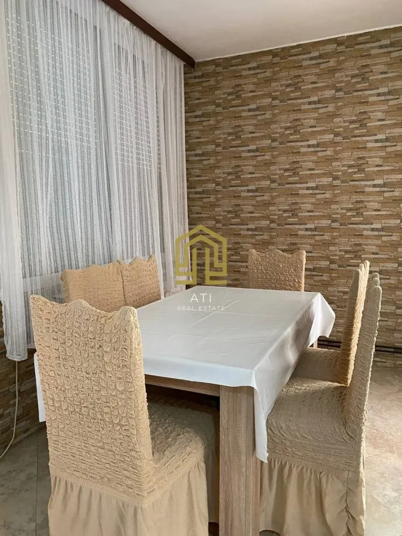 Dining room with a table, chairs, and a decorative wall.
