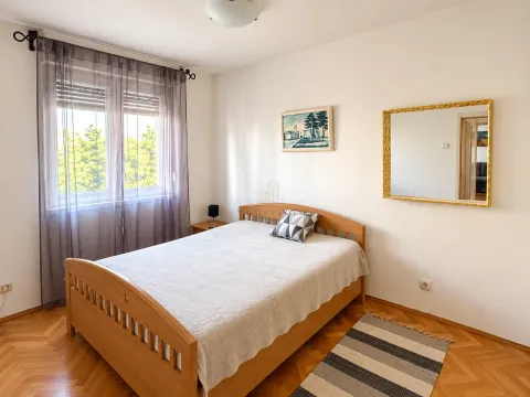 Namještena spavaća soba sa bračnim krevetom, prozorom i ogledalom na zidu. - image 6