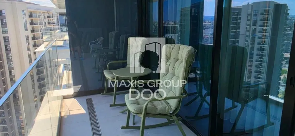 Furnished balcony with seating set and glass railing.