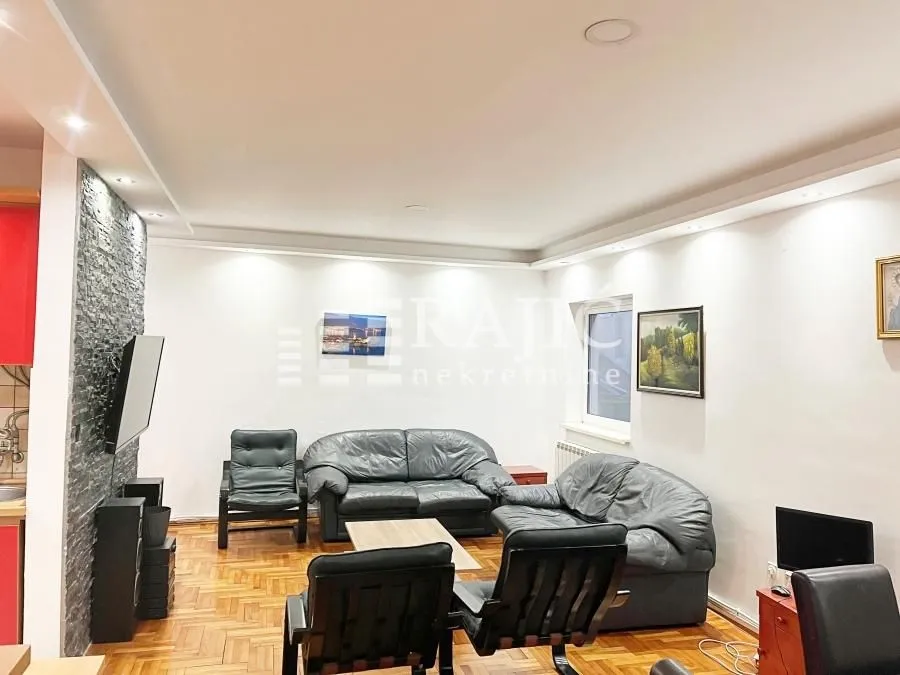 Living room with a seating set and parquet flooring.