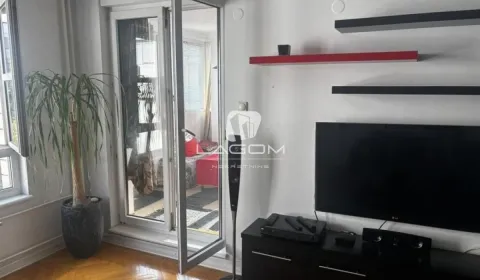 Living room with a TV, shelves and access to the terrace. - image 7