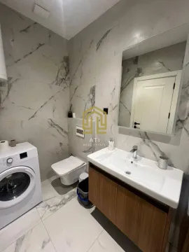 Moderne kupatilo sa mermernim pločicama, umivaonikom i veš mašinom. - image 17