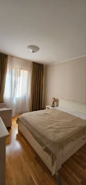 Spavaća soba sa bračnim krevetom, noćnim stočićem i prozorom sa zavjesama. - image 3