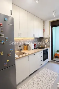 Pogled na moderno opremljenu kuhinju sa belim elementima i ugradnim uređajima. - image 5