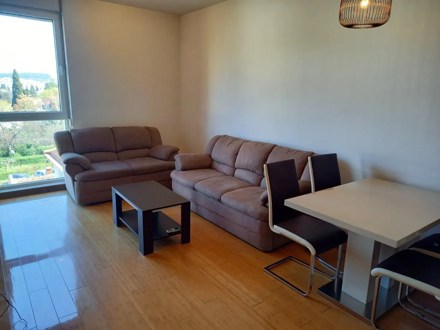 Bright living room with a seating area and a dining table.