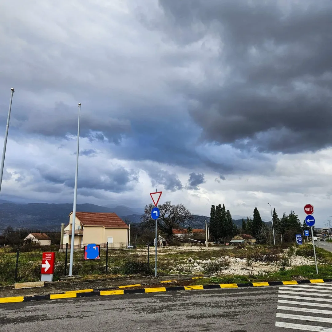 Pogled na zemljište i okolne kuće pored puta.