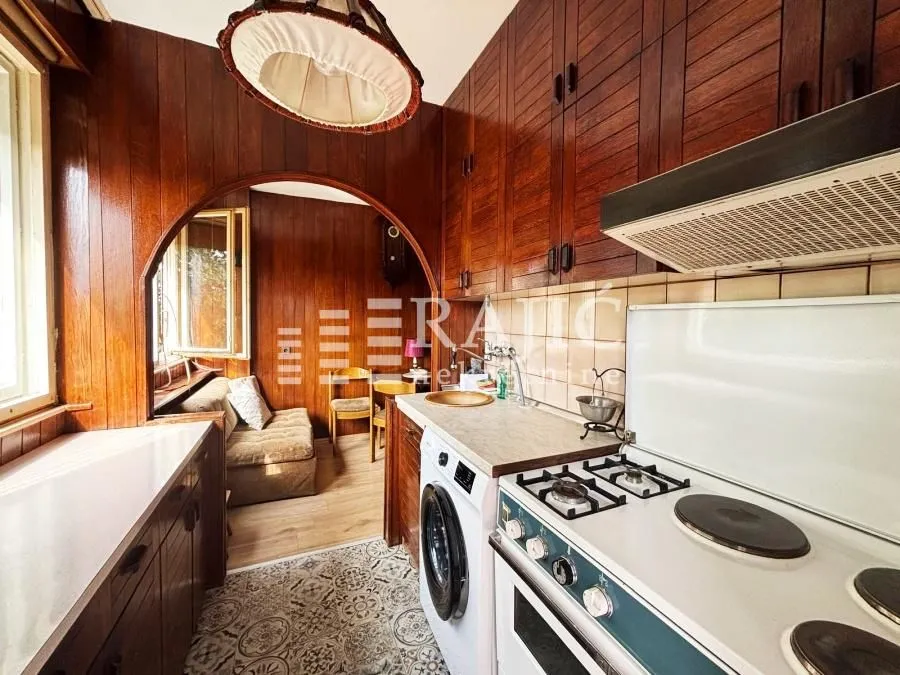 Smaller kitchen with wooden cabinetry and a view of the dining area.