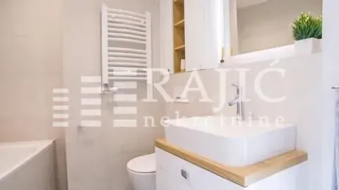 Modernly equipped bathroom with a washbasin, shower, and toilet. - image 10