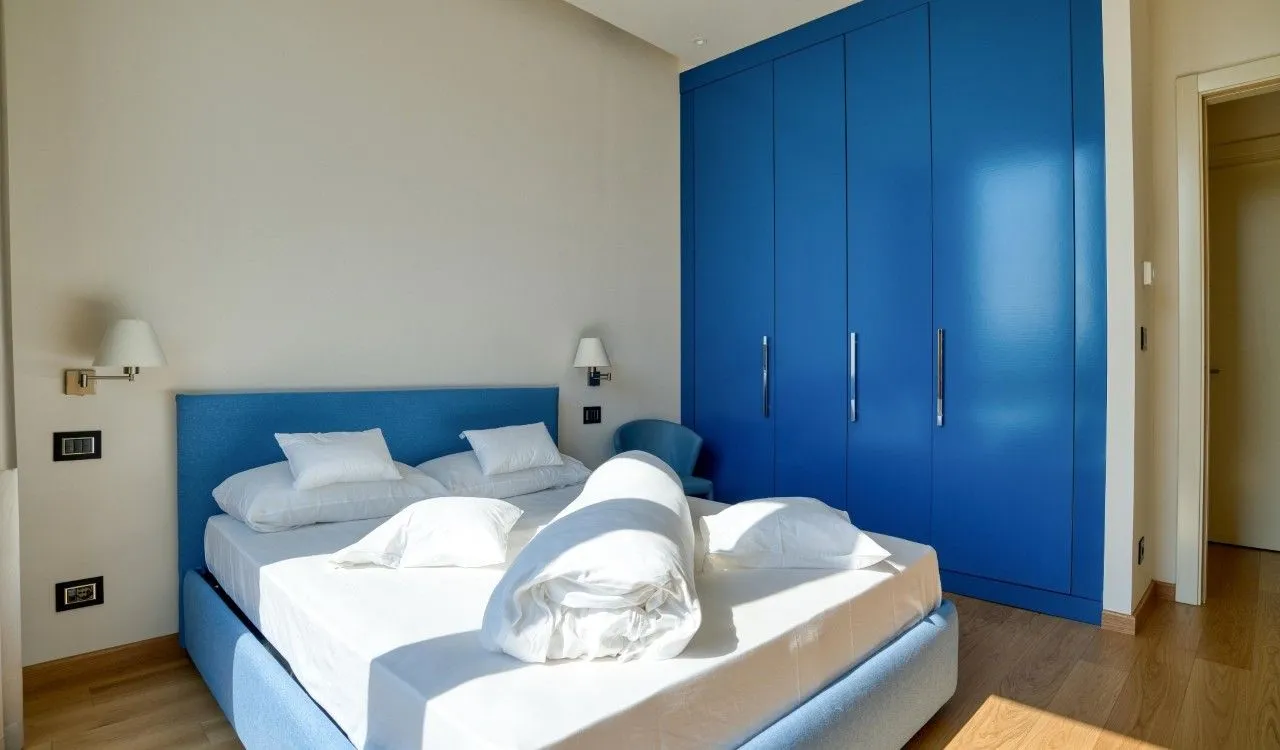 Bedroom with a double bed and a large blue wardrobe.