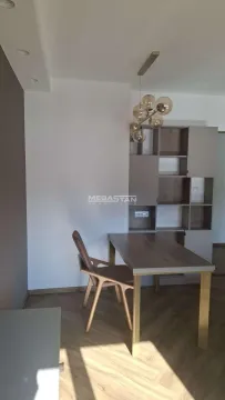 Dining table with chairs and wall units in the living room. - image 3