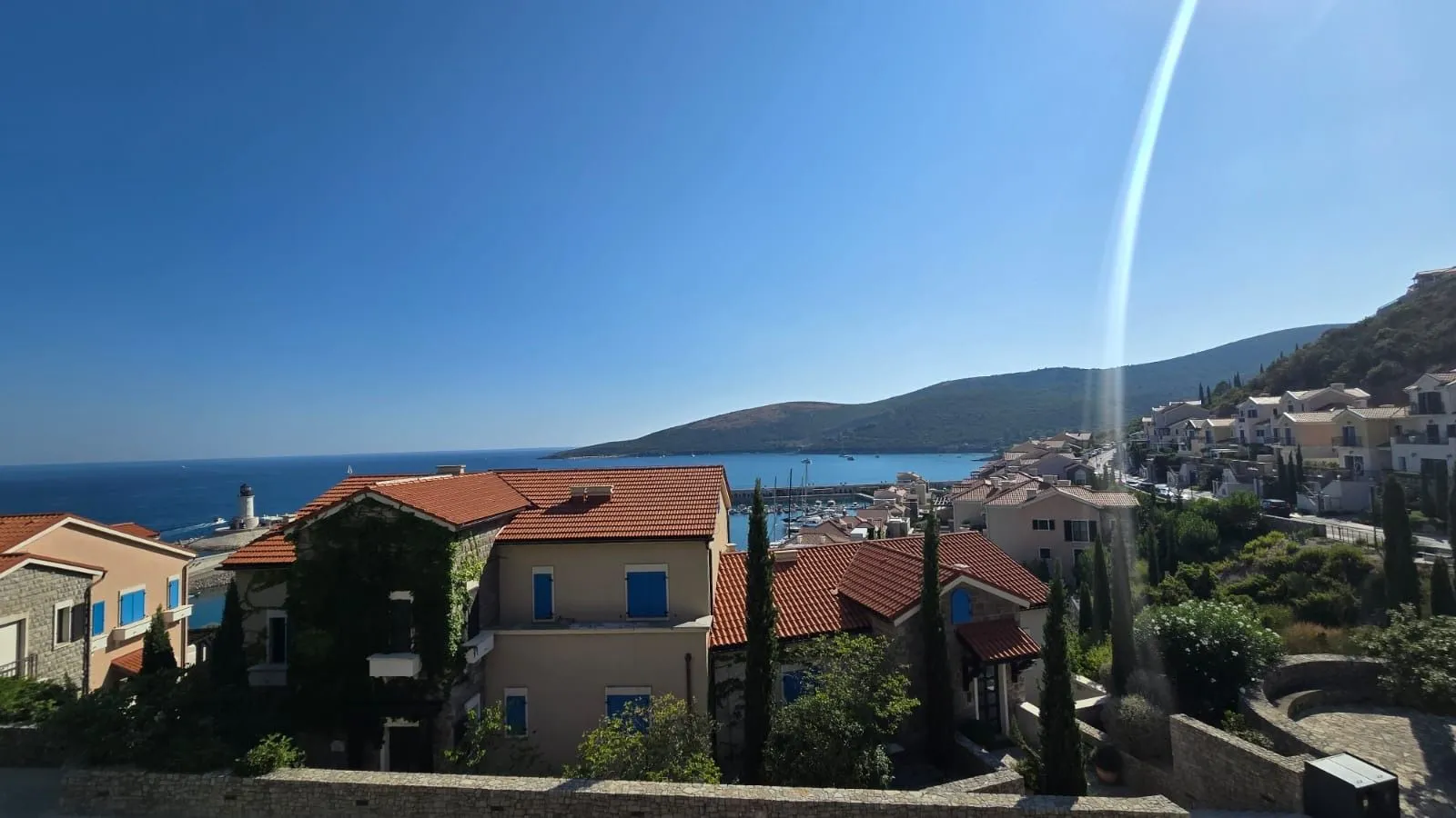 Pogled na more i okolno naselje sa mediteranskom arhitekturom.