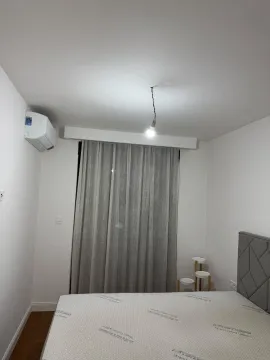 Smaller bedroom with a double bed, air conditioning unit, and curtains. - image 8