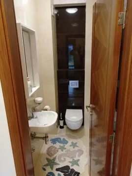 Smaller bathroom with a washbasin and toilet. - image 13