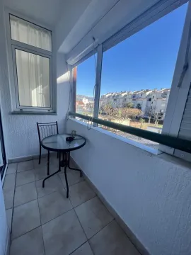 Zastakljeni balkon sa malim stolom i stolicom. - image 10