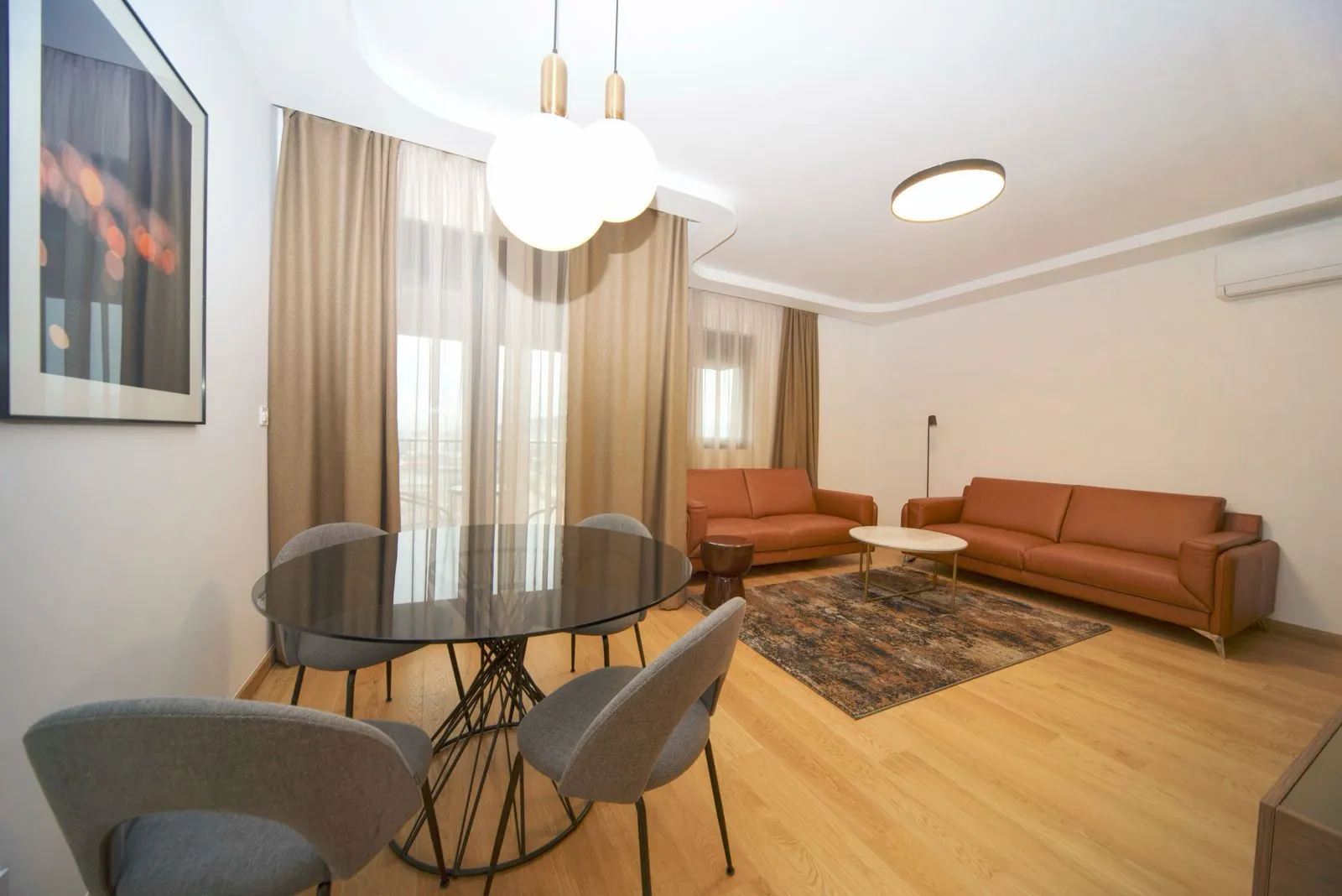 Living room with a dining area, sofa set, and round table.