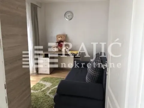 Living room with a sofa and a desk. - image 7