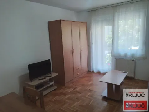 Dnevna soba sa ormanom, televizorom i izlazom na terasu. - image 7