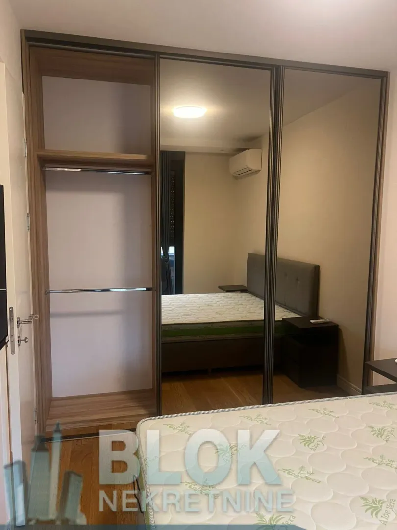 Bedroom with a large built-in mirrored wardrobe and a double bed.