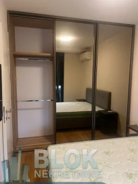 Bedroom with a large built-in mirrored wardrobe and a double bed. - image 3
