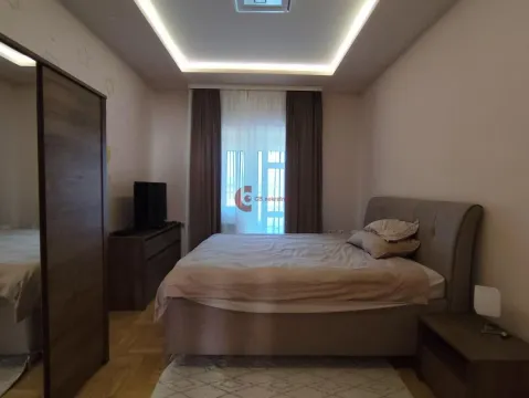 Furnished bedroom with a double bed, wardrobe, and TV unit. - image 23