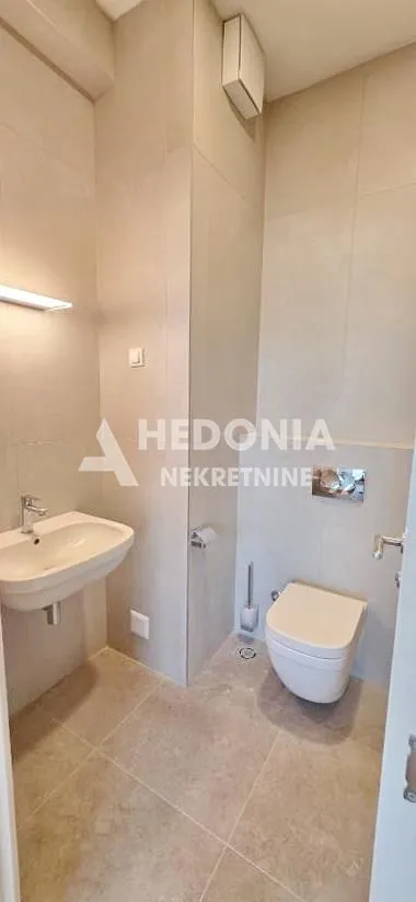 Moderno opremljeno kupatilo sa umivaonikom i wc šoljom.