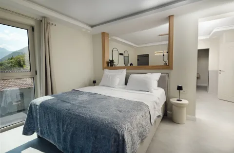 Moderna spavaća soba sa bračnim krevetom, noćnim stočićima i velikim prozorom. - image 6