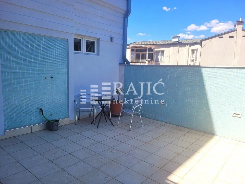 Spacious terrace with tiles and outdoor seating.