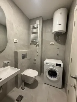Moderno kupatilo sa veš mašinom, bojlerom i sivim pločicama. - image 13