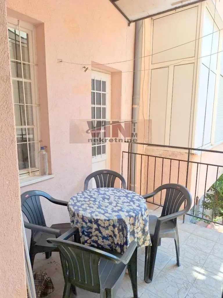Natkriveni balkon sa stolom i stolicama.