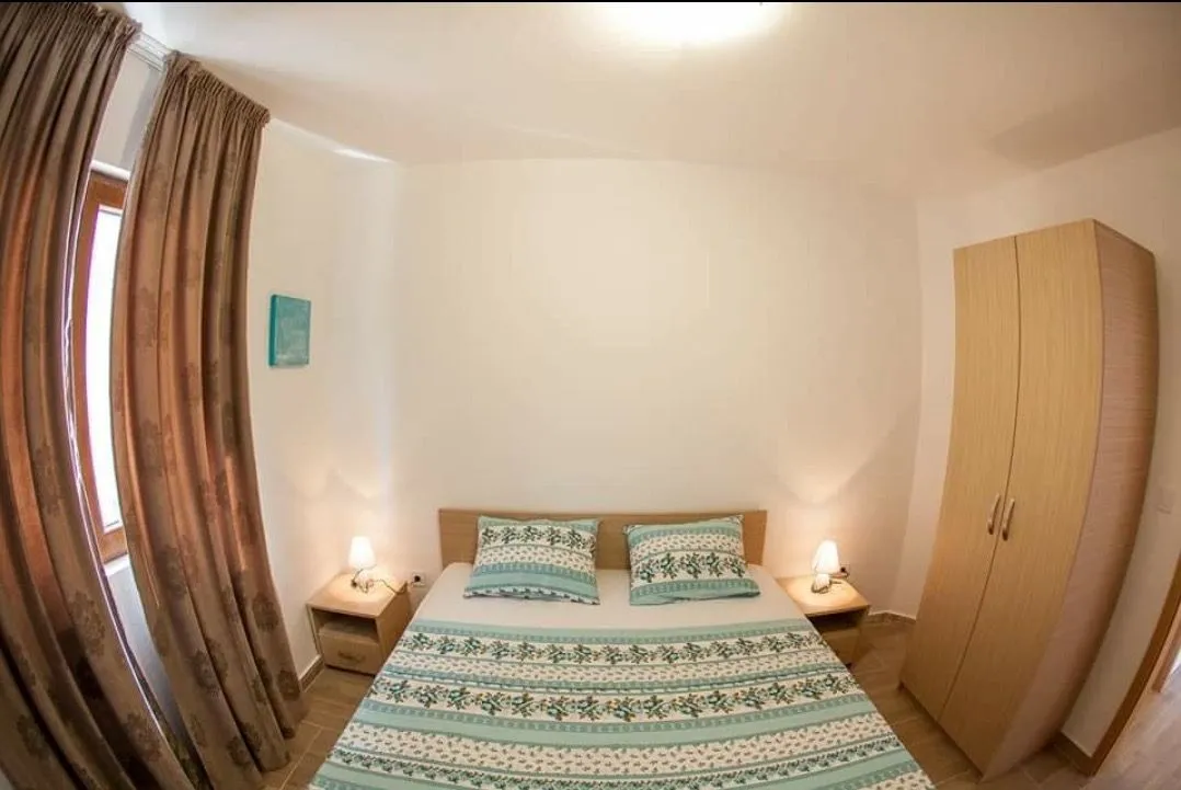 Furnished bedroom with a double bed, wardrobe, and nightstands.