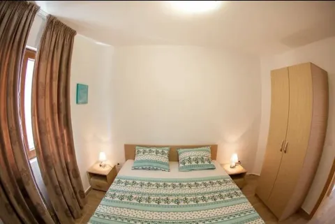 Furnished bedroom with a double bed, wardrobe, and nightstands. - image 5