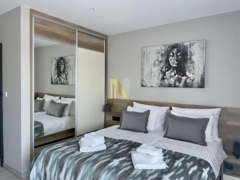 Furnished bedroom with a double bed, mirrored wardrobe, and wall art. - image 7